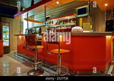 Bar counter and barstools  in empty cafe-bar with orange interior Stock Photo