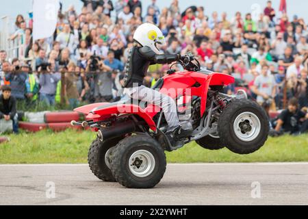 MOSCOW - AUG 25: Kid rides on the rear wheels on a quad bike on Festival of art and film stunt Prometheus in Tushino on August 25, 2012 in Moscow, Rus Stock Photo