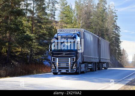 New, beautifully customised black Volvo FH16 750 truck with curtainside trailer transports goods along highway. Salo, Finland. April 19, 2024. Stock Photo