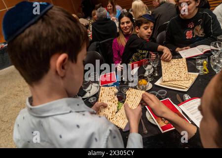 Buenos Aires, Argentina. 23rd Apr, 2024. Children share the matzah. The Jewish community of Amichai celebrates a communal Seder evening on the second night of Passover. Credit: Guido Piotrkowski/-//dpa/Alamy Live News Stock Photo