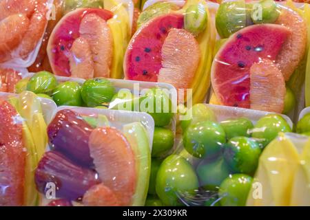 Colorful Fruits. Fruits wrapped in plastic on sale. Exotic fruits on display. The most delicious fruits. Stock Photo
