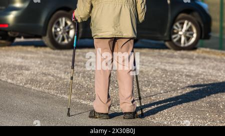 Oberglatt, Schweiz - 25. Januar 2022: Ein Rentner spaziert mit Gehstöcke auf einer Strasse und geniesst den Tag. Stock Photo