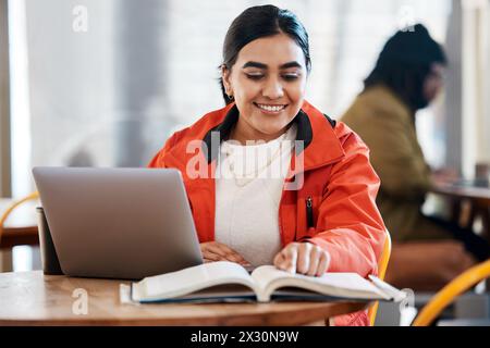 Girl, laptop and cafe with book on table for knowledge, education and research for assignment. University, campus and student with textbook on desk in Stock Photo