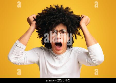 Emotional black man in despair pulling out his hair Stock Photo