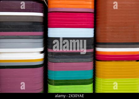 Multi-colored plastic plant containers stacked tightly in rows to form an abstract display of color and texture. Stock Photo
