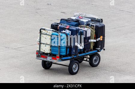 Ein Wagen mit Reisekoffern steht auf dem Vorfeld des Flughafen Zürich. (Zürich, Schweiz, 24.05.2022) Stock Photo