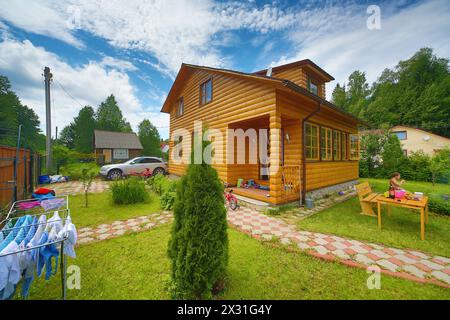 Man resting at a table outdoors next to a wooden house Stock Photo