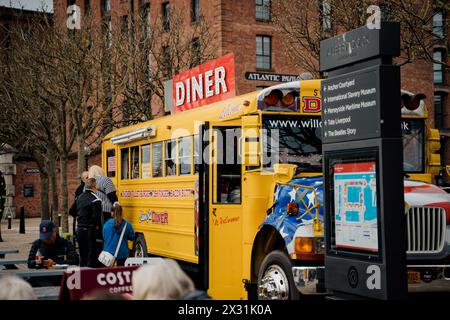 Liverpool, UK, April 11 2024: The yellow bus transformed into a food truck, from the Albert Dock, serves food to passers-by visiting the city of Liver Stock Photo