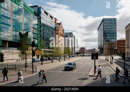 Liverpool, UK, April 11 2024: People cross The Strand street, near the Beetham Plaza building. The image captures the city of Liverpool at rush hour. Stock Photo