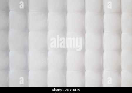 The wall with white quilted pattern consisting of equal squares Stock Photo