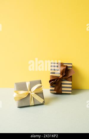 Gift boxes on gray table. yellow wall background Stock Photo