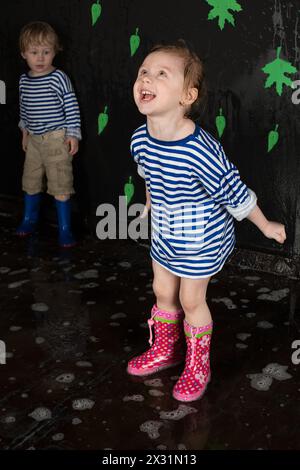 A smiling little girl and boy in a striped vest, focus on girl Stock Photo