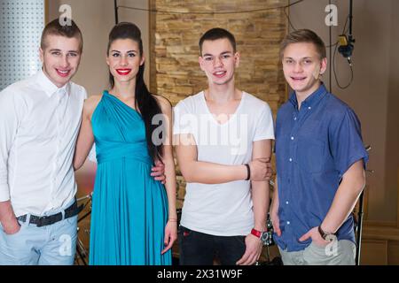 Three guys musician and a girl singer in the Recording Studio, with property release Stock Photo
