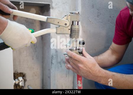 Workers swaged pipe heating system in the apartment Stock Photo