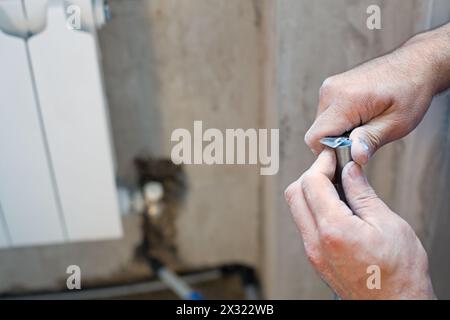 A worker cleans the pipe preparing it for crimping Stock Photo