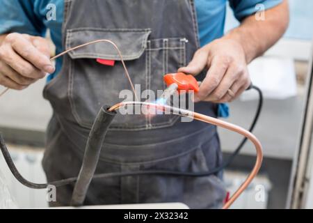 Worker the air conditioner pipe welds oxyfuel gas welding Stock Photo