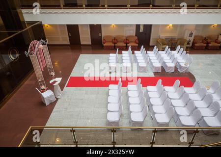 Empty hall for a wedding ceremony with decorated chairs Stock Photo