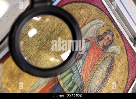 Cracow. Krakow. Poland.  Craquelure cracks in the paint of old picture seen through the magnifying glass. Stock Photo