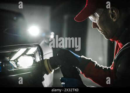 Caucasian Man Polishing Vehicle Body After Waxing. Car Detailing Theme. Stock Photo