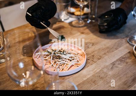 Chef Garnishing Dish with Fresh Herbs for Culinary Event Stock Photo