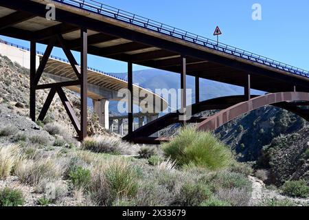 Old steel road bridge next to more modern concrete bridge over ravine by village of Ízbor, Spain in dry rocky habitat Stock Photo