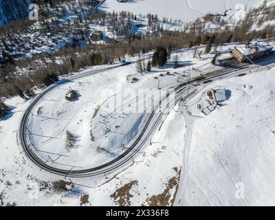 Aerial image of the Rhaetian Railway track with the famous tight 180° curve at high Alp Grum over Berina Pass down into the Poschiavo Valley, Canton G Stock Photo