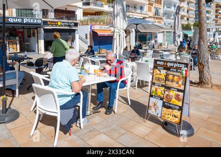 Porto Cristo, Balearic Islands, Spain, Tourists eating a pizza in the street of Carrer d'en bordils, Editorial only. Stock Photo