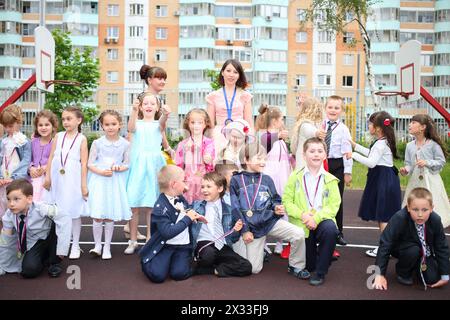 Group of nineteen children with two educator outside in kindergarten Stock Photo