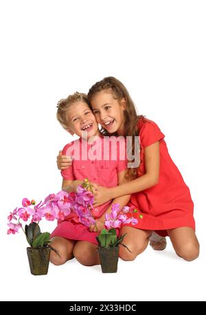 Portrait of two happy girls with orchids in pots isolated on white Stock Photo