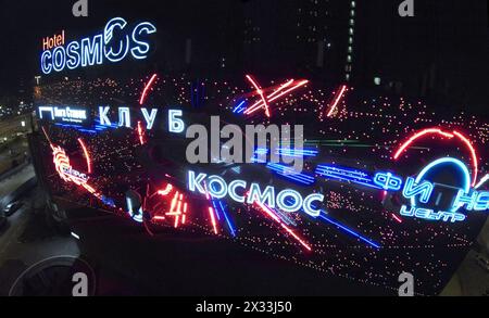 MOSCOW, RUSSIA - MAR 7, 2014: The neon sign of Cosmos Hotel Club are lighting on the photodiode desk. Stock Photo