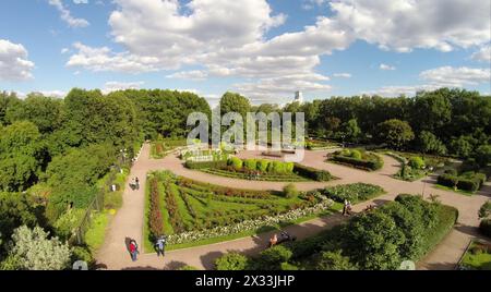 RUSSIA, MOSCOW - JUN 22, 2014: People walk by paths in rose garden at summer sunny day. Aerial view. Photo with noise from action camera Stock Photo