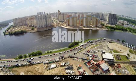 RUSSIA, KRASNOGORSK - JUN 6, 2014: Cityscape with playground for off-road test drives of Jeep company and tall dwelling houses on shore of Moscow rive Stock Photo