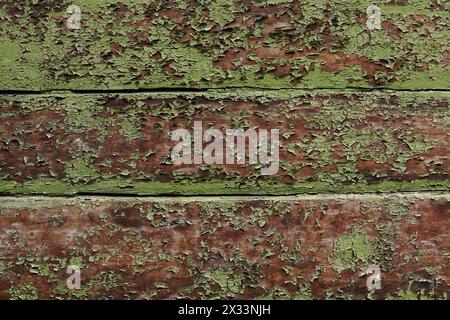 Old wooden wall with green cracked paint. The texture of an old wooden board covered with irradiated paint.  Stock Photo