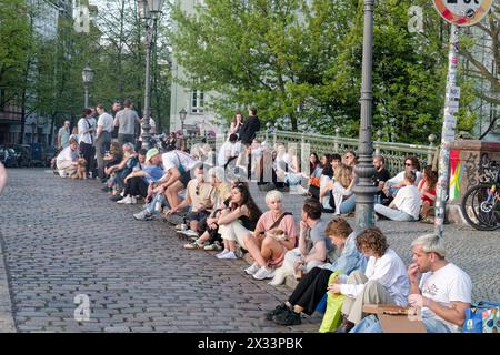 Junge Leute sitzen in Gruppen an der Admiralsbrücke in Kreuzberg, Berlin Stock Photo