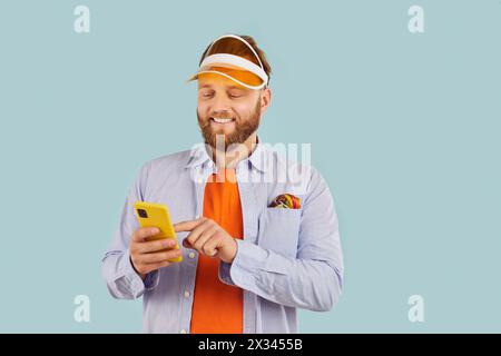 Happy Caucasian Man Using Phone On Blue Background Stock Photo