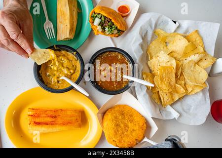 View from above of authentic Mexican meal from above featuring chips, tamales, gorditas and salsa. Stock Photo