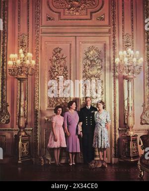 Royal family portrait taken inside a stateroom of Windsor Castle, dated 1944. From left to right, Princess Margaret, Queen Elizabeth (later known as the Queen Mother), King George VI, and Princess Elizabeth (the future Queen Elizabeth II) are captured during the latter years of the Second World War. Stock Photo