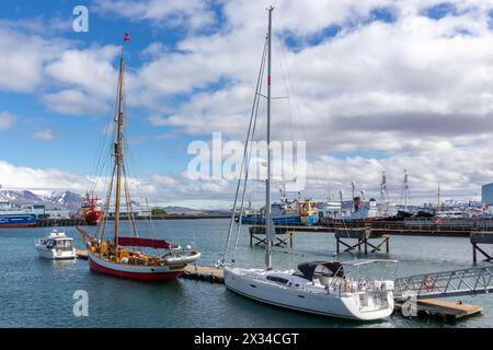 Reykjavik, Iceland, 14.05.22. Sailboats, motorboats, tourist ships, and fishing boats docked in Reykjavik Harbor with Mount Esjan mountain. Stock Photo