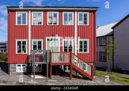 Traditional Icelandic ironclad red residential house with white window frames, clad in corrugated metal sheets in Reykjavik, Iceland. Stock Photo