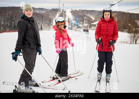 Woman and two children ski in winter at ski resort. Stock Photo