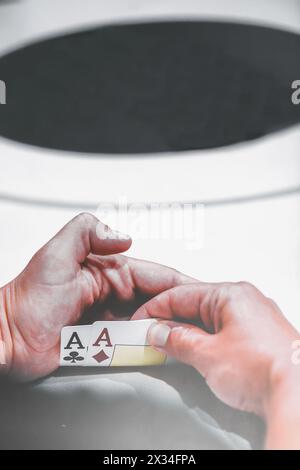 Close-up view of a poker players hands covertly holding a pair of aces, the strongest starting hand in Texas Holdem Stock Photo