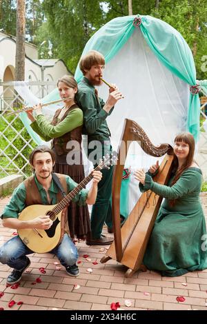 MOSCOW, RUSSIA - MAY 30, 2015: Young musicians of musical Band Polca an Ri play music against arch decorated green and white fabrics. Polca an Ri play Stock Photo