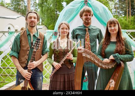 Young musicians of musical Band stand against arch decorated green and white fabrics Stock Photo