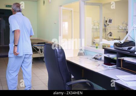 The man moves away from the workplace of the nurse near the intensive care unit, view from the back Stock Photo