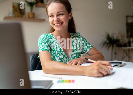 Adult students concept. Adult woman studying online at home using her laptop, video calls to her tutor. Stock Photo
