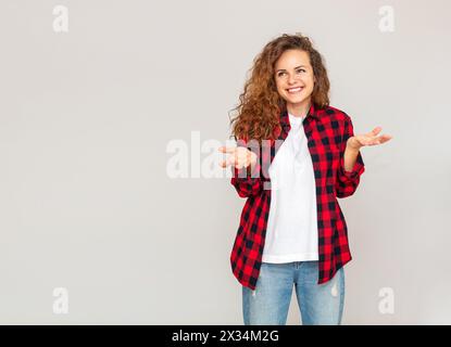 Woman in casual clothes smiles and expresses a confusion of choice. Stock Photo
