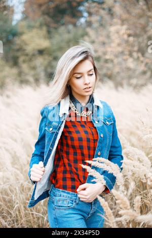 Beautiful Stylish Girl In Denim Jacket, Checkered Red Shirt And Blue Jeans. Stock Photo