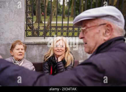 A senior man talking to two women on a bench. united family in a park Stock Photo