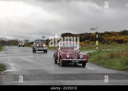 A procession of vintage cars led by a Bristol 400 leave Caldbeck, Cumbria.  The cars are taking part in the Flying Scotsman Rally, a free public-event Stock Photo