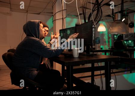 Hackers team planning cyberattack on internet, talking about malicious software code to crack firewall encryption. Online criminals breaking into database, information. Internet fraud. Stock Photo